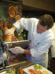 Chef slicing prosciutto